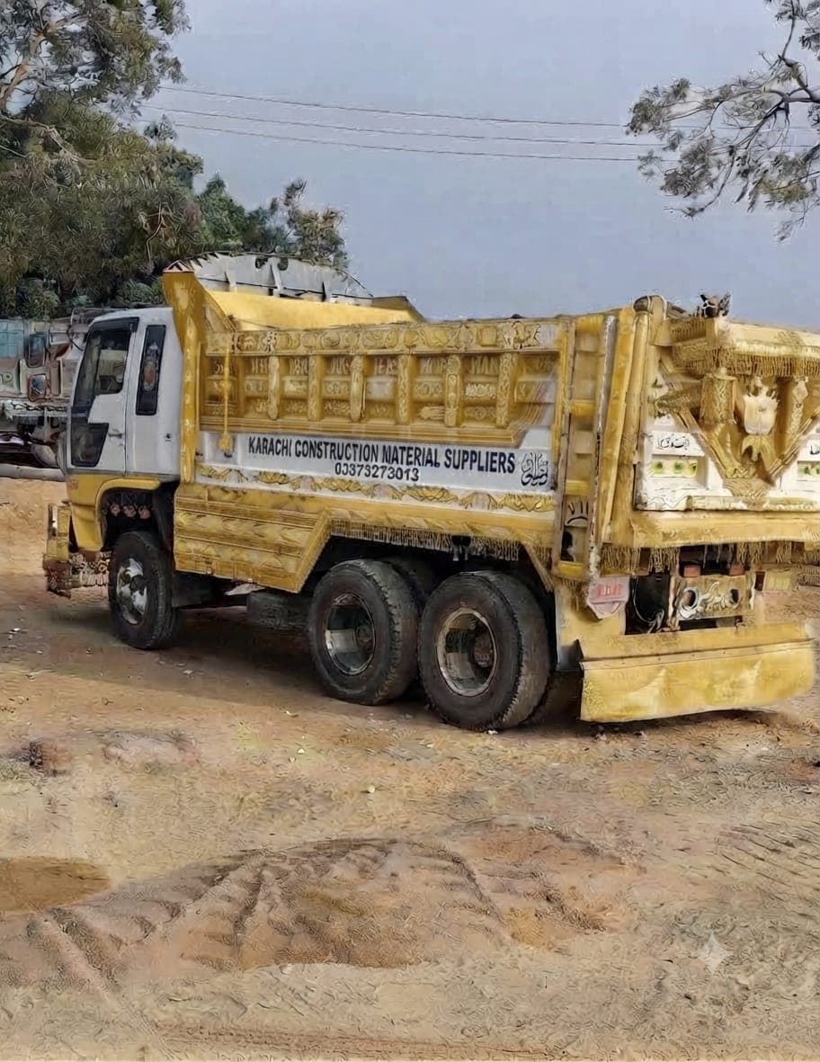 The company dumper from the side, lettered with the company name and phone number on its painted panel